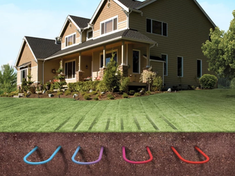 House with underground colored pipes for a geothermal heating system, shown in a lawn.