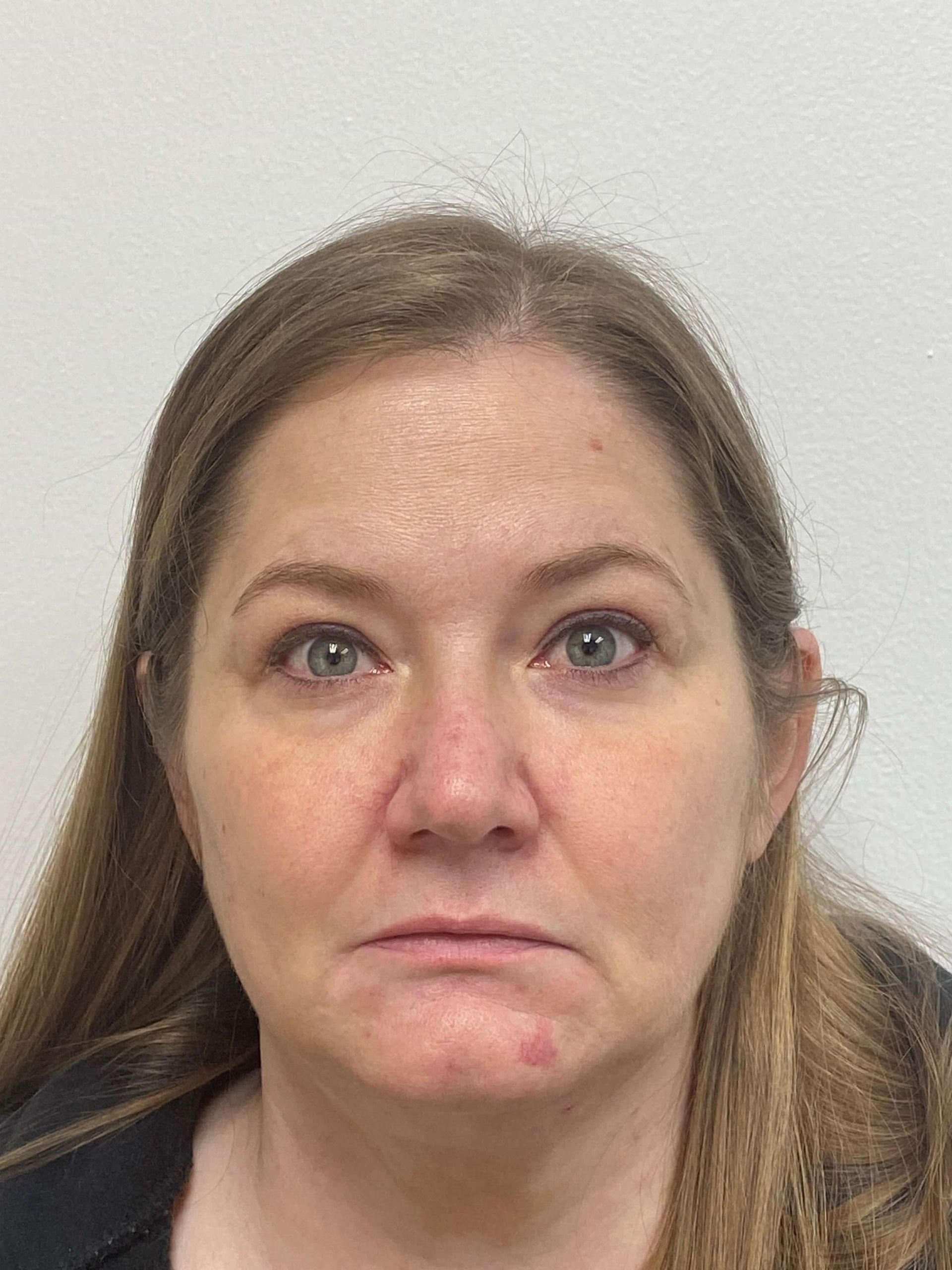 A headshot of a person with long light brown hair against a plain white background, showing a neutral expression.