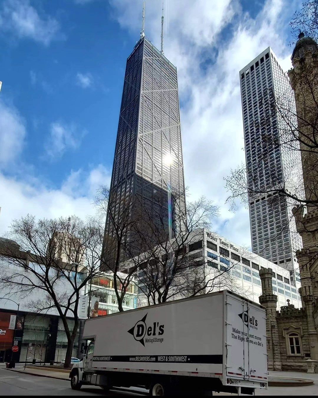 A moving truck in front of the John Hancock Center skyscraper