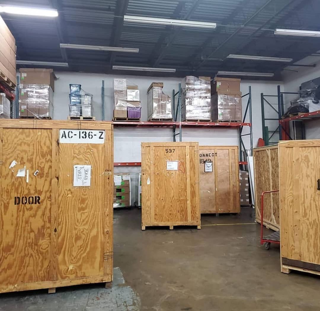 Warehouse interior with wooden crates and boxes on shelves.