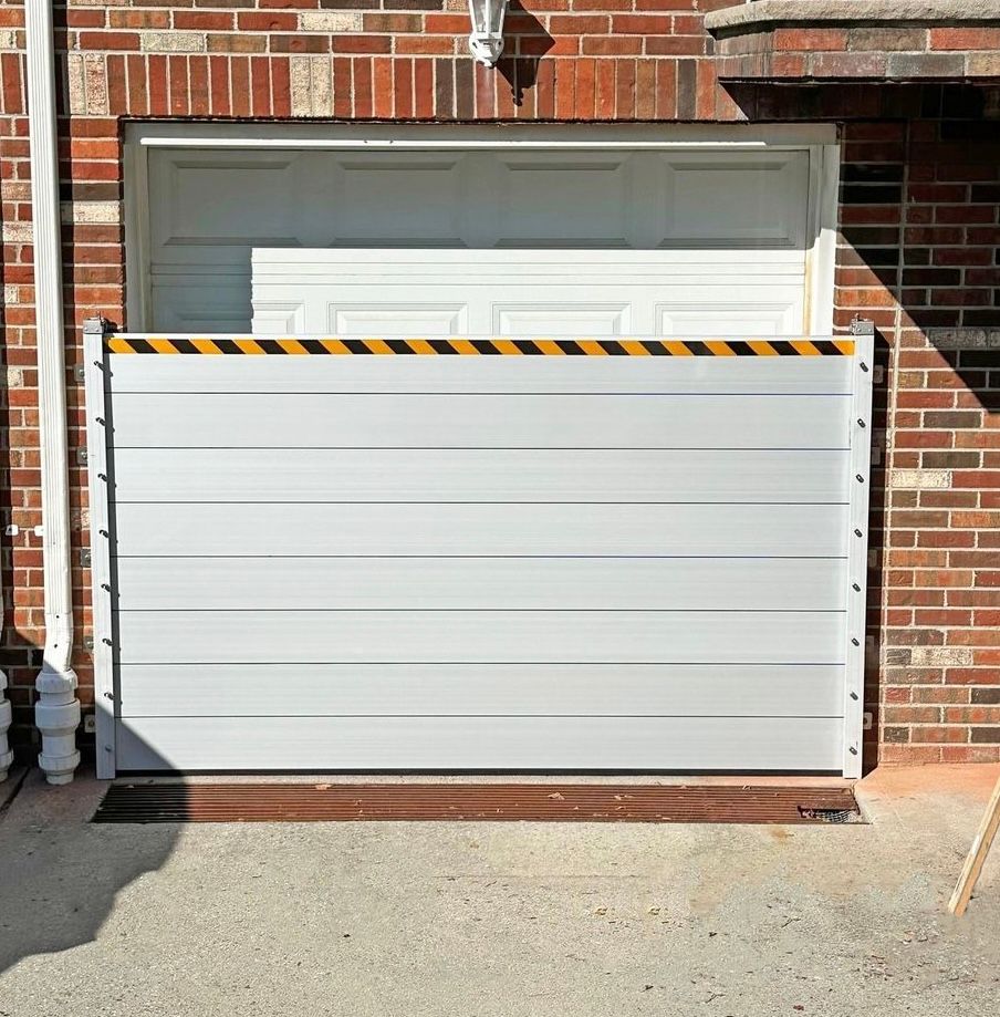 Red brick house with white flood barriers in front of the garage door