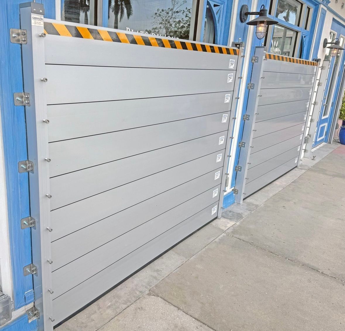 Gray flood barrier on a blue house