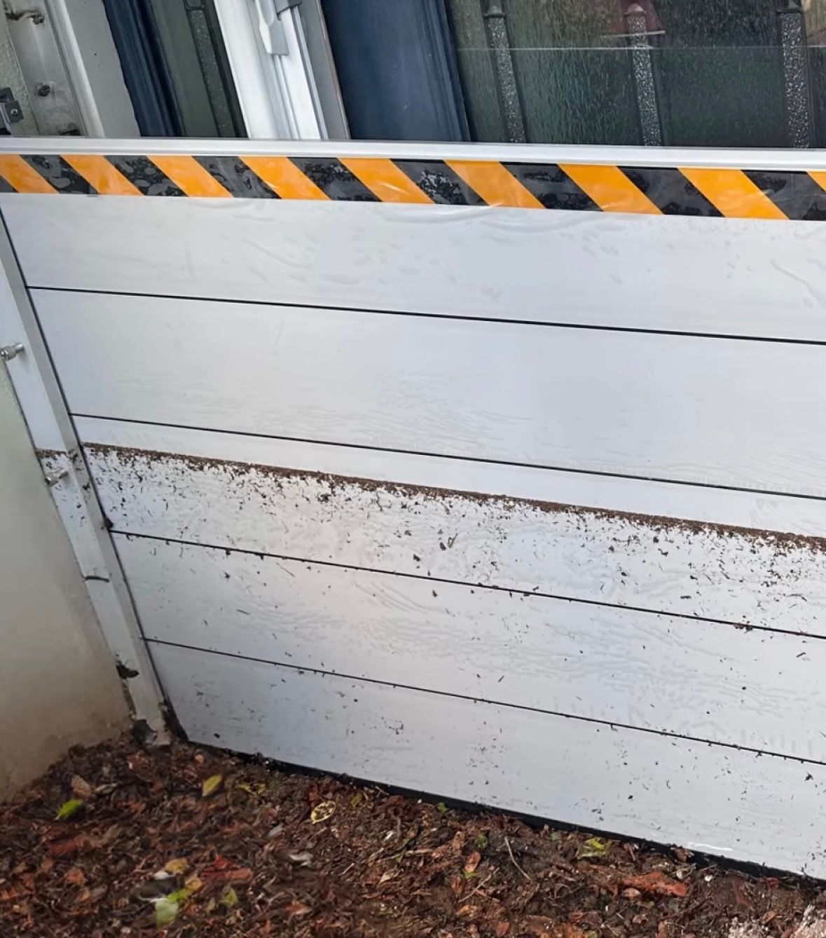 Flood barrier with dirt and leaves on the ground