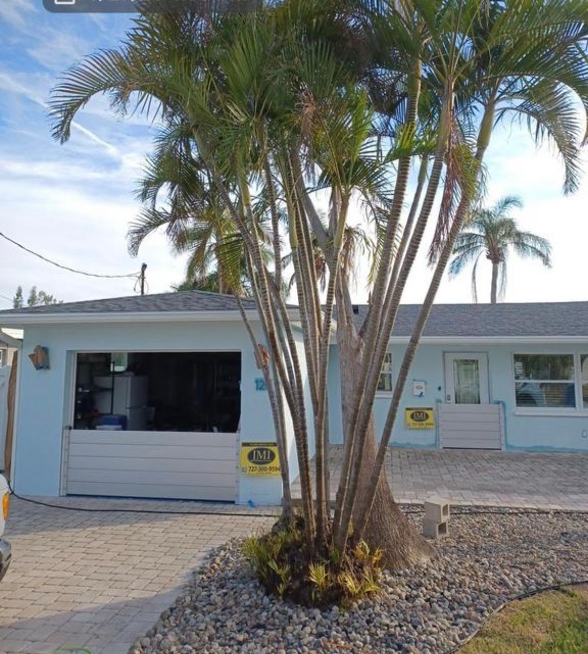 Light blue house with flood barriers in front of a door and garage door