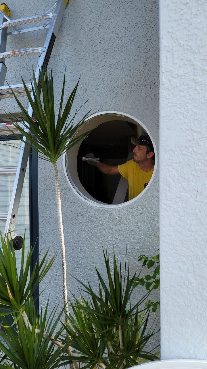 Man painting inside a round window
