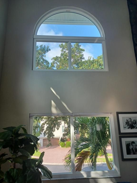 Sunlit indoor room with tall arched and rectangular windows