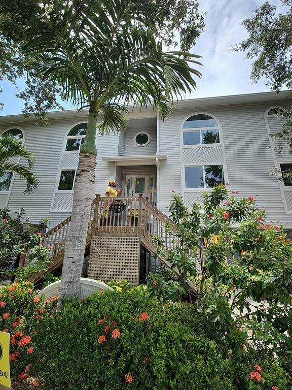 White apartment building with arched windows and palm trees