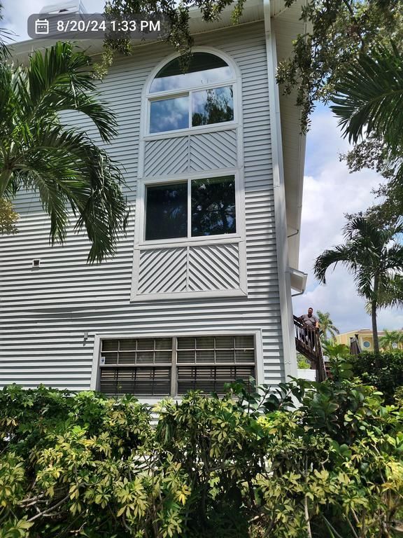 White apartment building with arched windows and palm trees in front