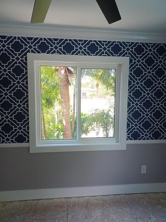 Room with patterned wallpaper and white-framed window