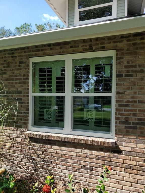 White-framed double window on a brick house