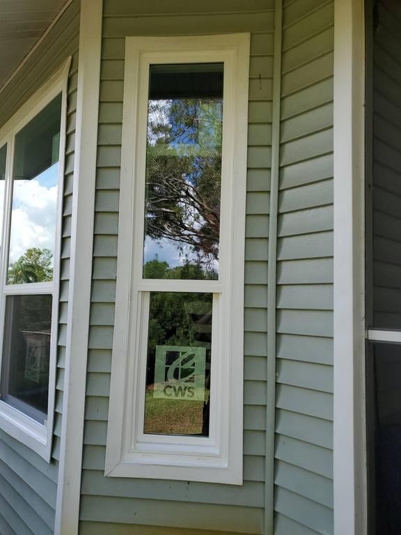 Narrow vertical window beside a house exterior with white trim