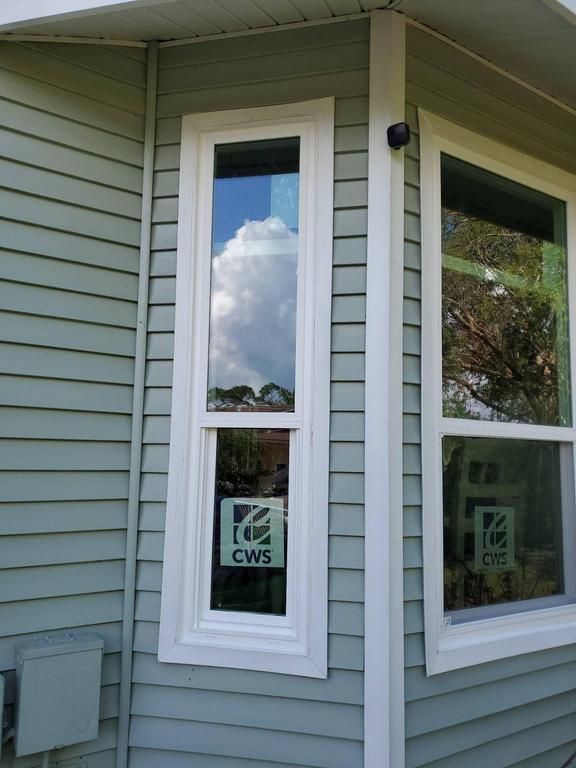 Exterior corner of a house with white-trimmed windows