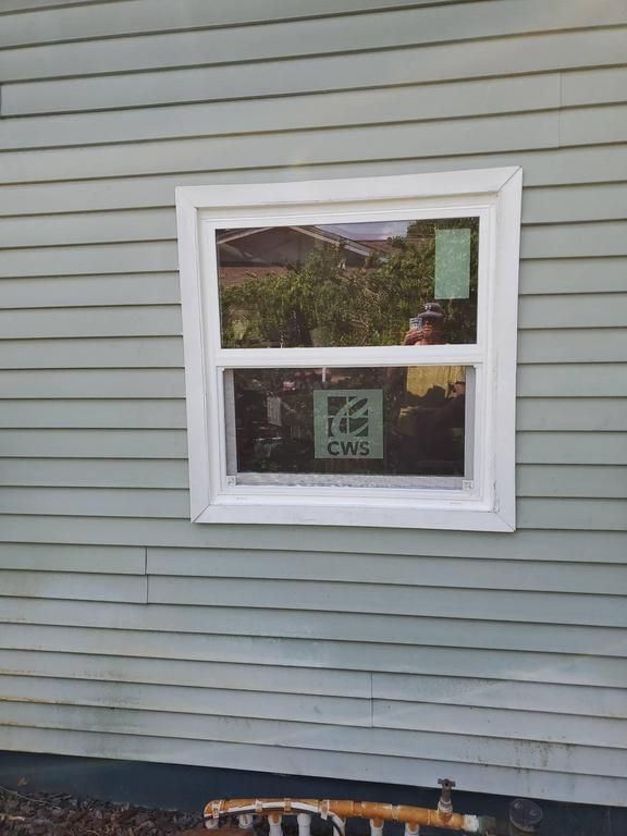 White-framed CWS window in gray house