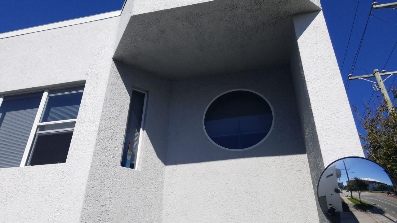 Modern white building facade with a round window