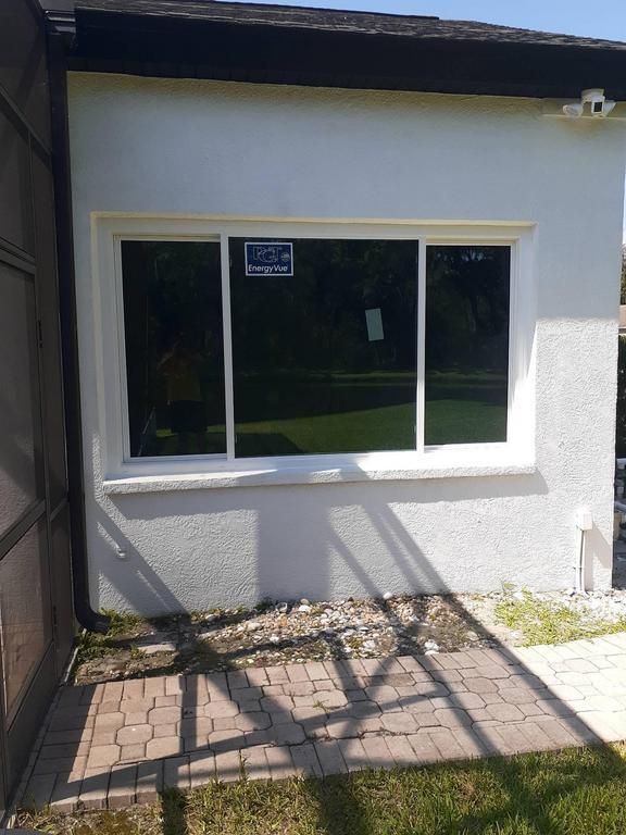 White stucco house wall with a large window