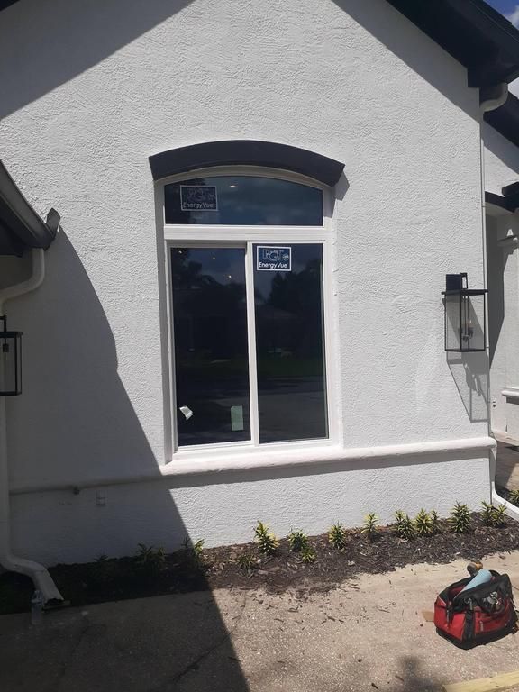 White stucco house exterior with an arched window