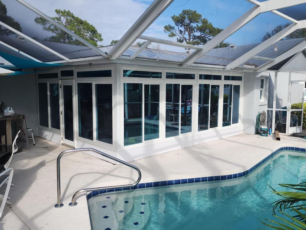 Screened pool enclosure with white patio doors and windows