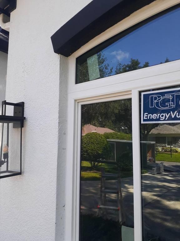Glass front door with sign and white exterior wall
