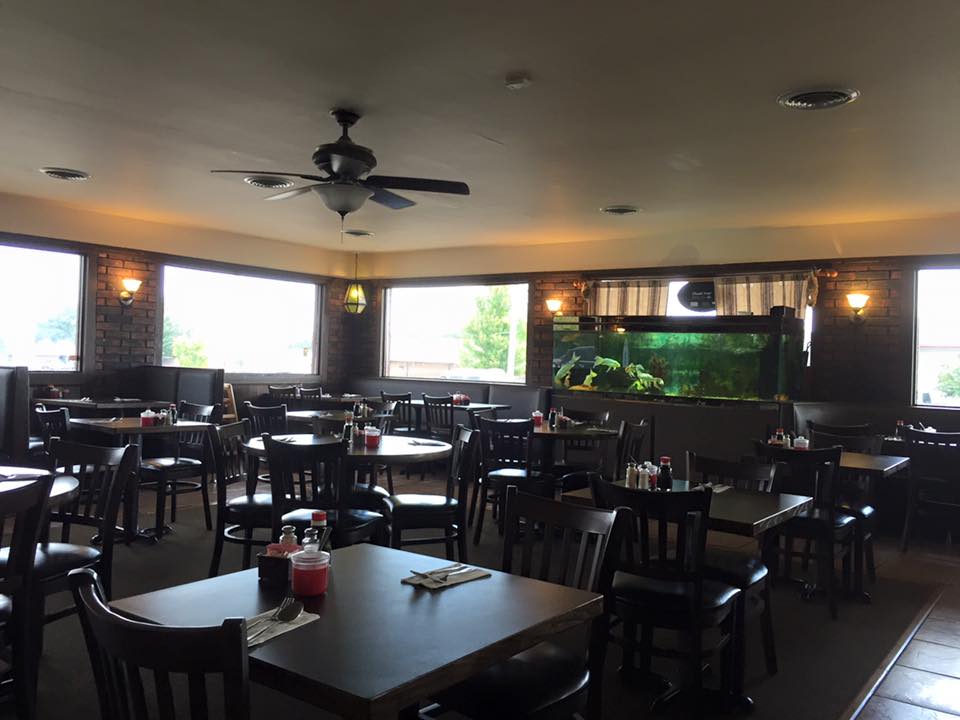 A restaurant with tables and chairs and a ceiling fan