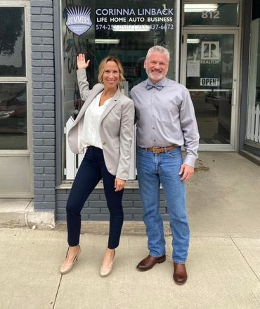 A man and a woman are standing in front of a building.