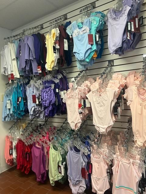 A store filled with lots of children 's clothes hanging on a wall.