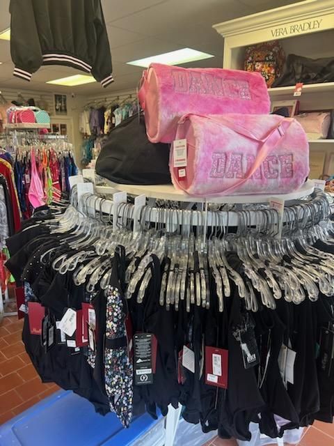 A bunch of clothes are hanging on a rack in a store