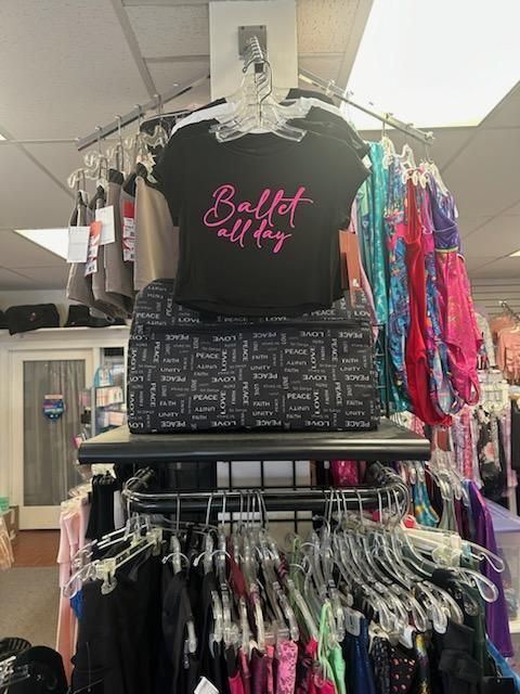 A store filled with lots of clothes and a t-shirt that says ballet calling.