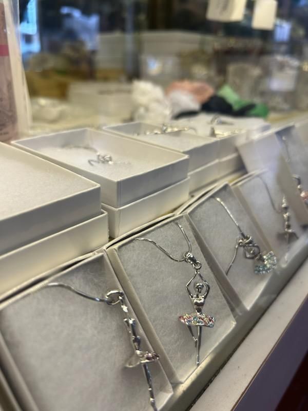 A display of silver jewelry including a ballerina necklace