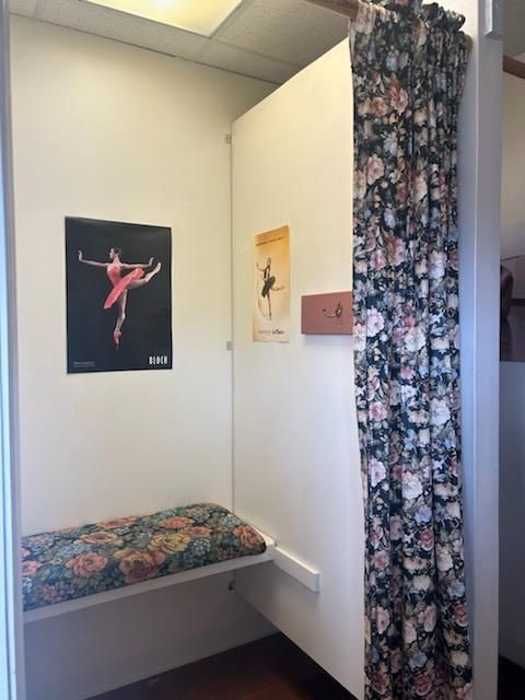 A dressing room with a picture of a ballerina on the wall