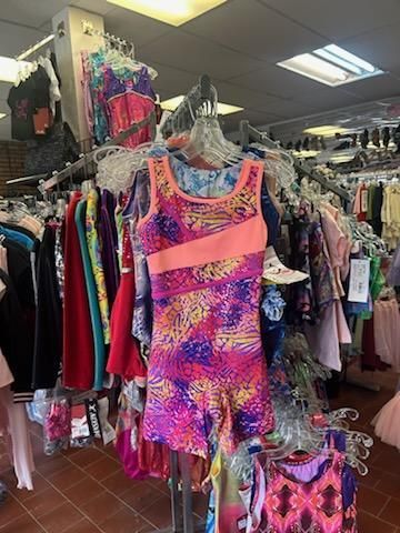 A colorful dress is hanging on a rack in a store.