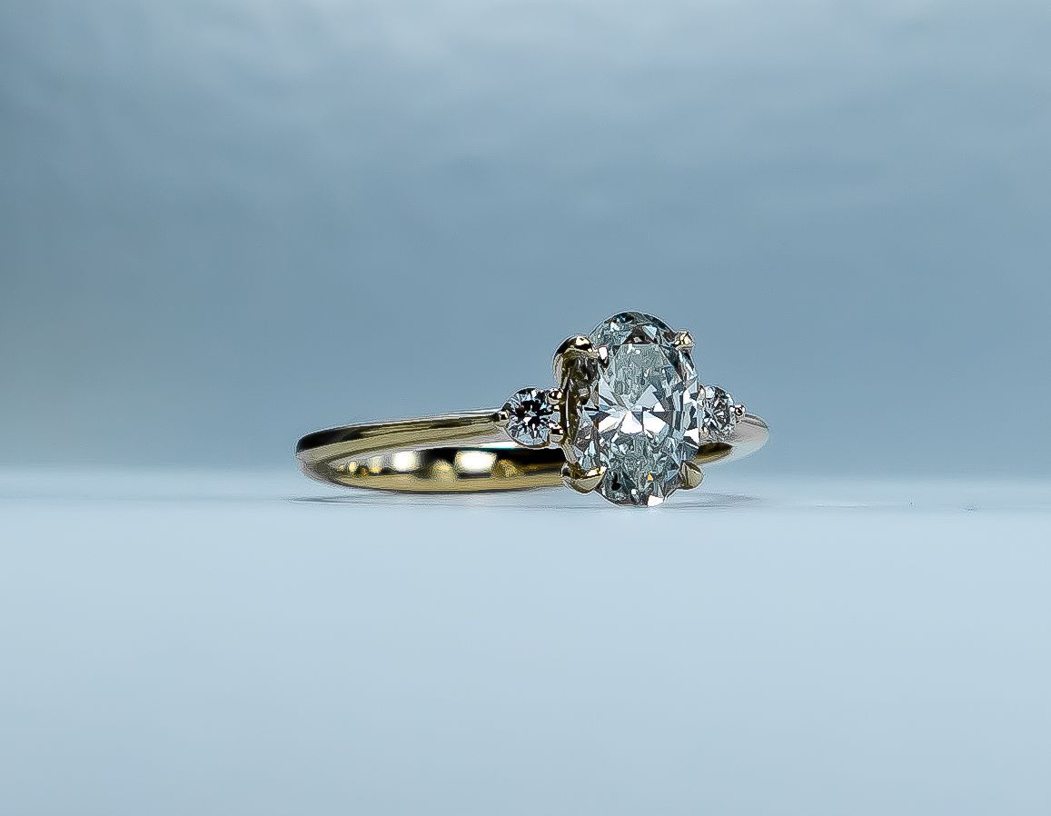 Gold ring with a clear gemstone on a light blue background