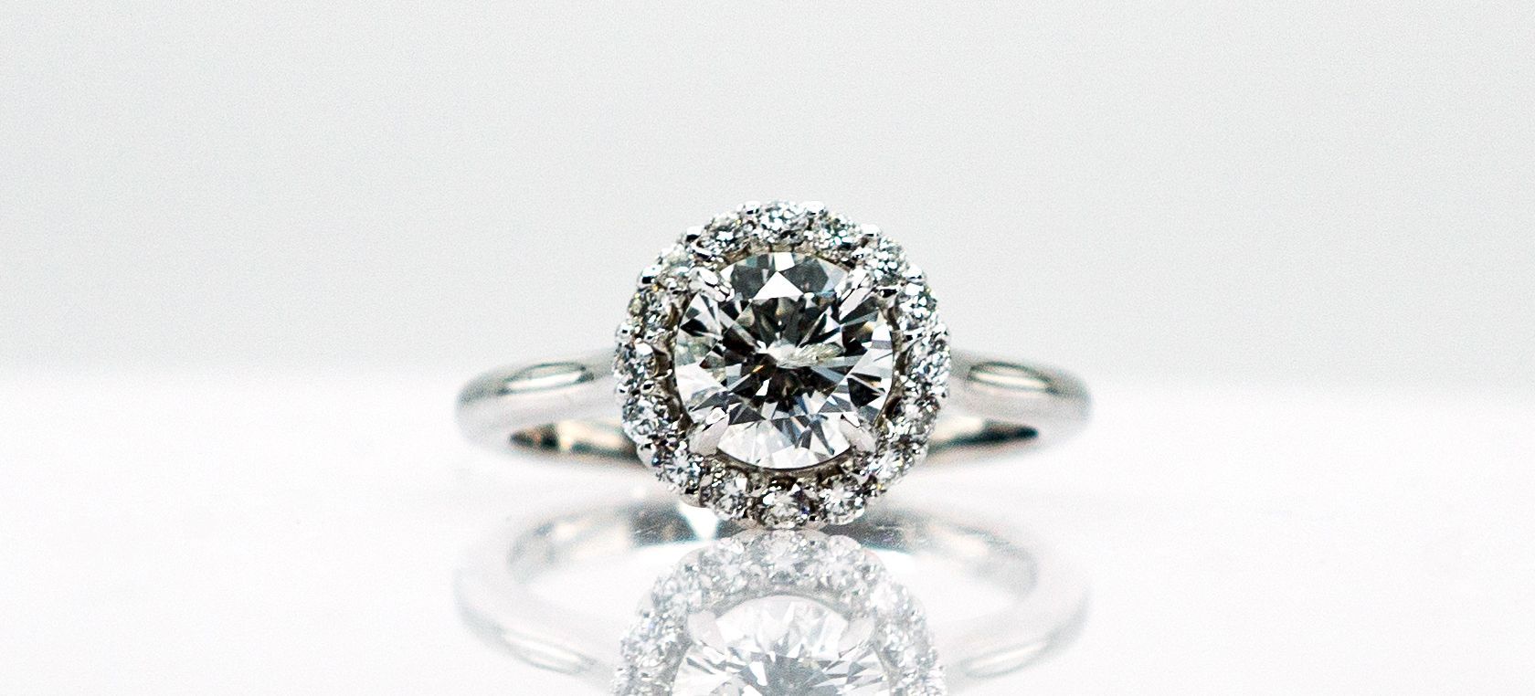 Silver ring with a large round diamond on a white background