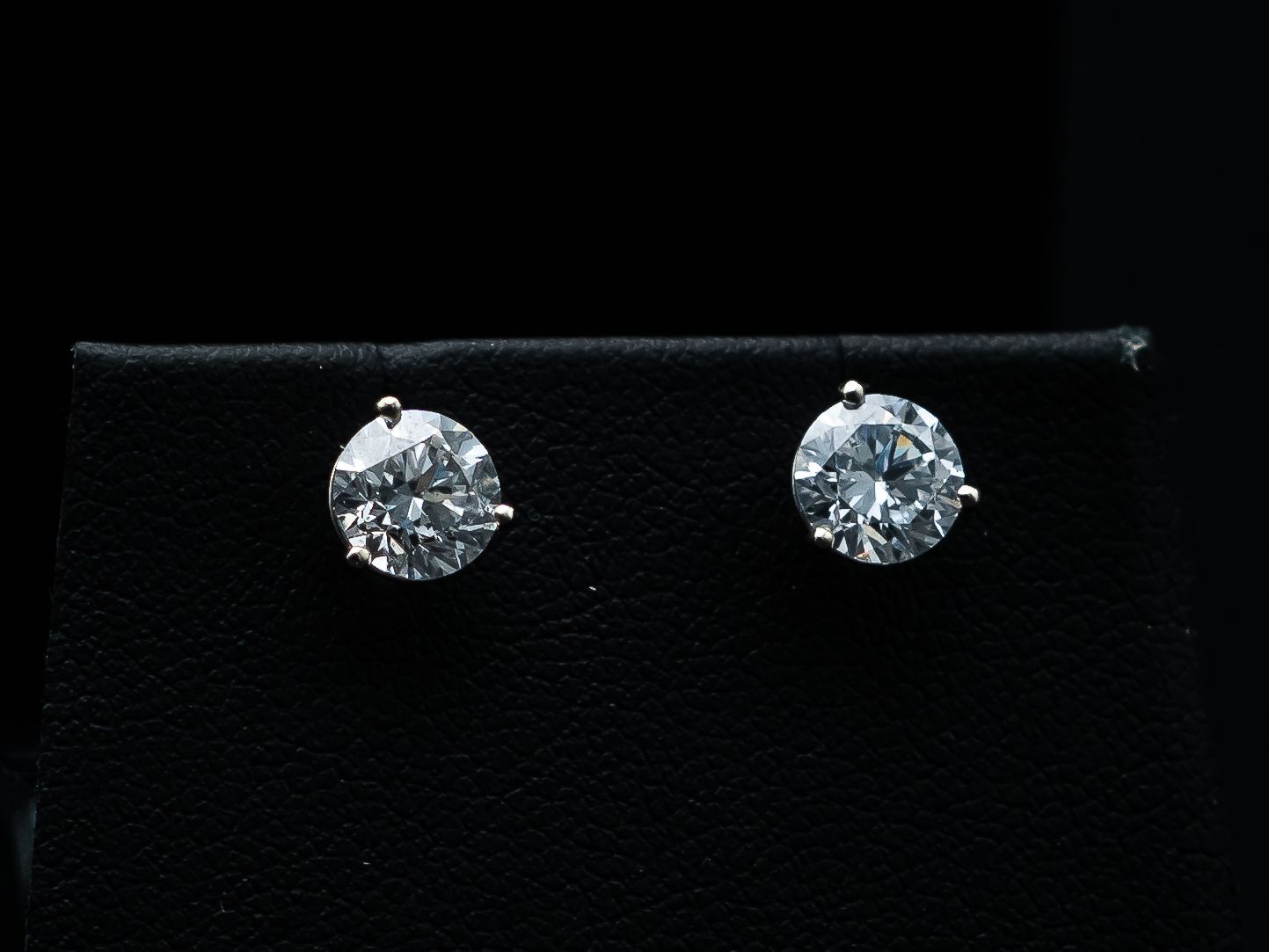 Pair of diamond stud earrings on a black background