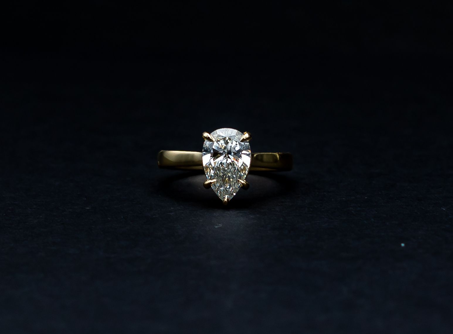 Pear-shaped diamond ring on a dark background