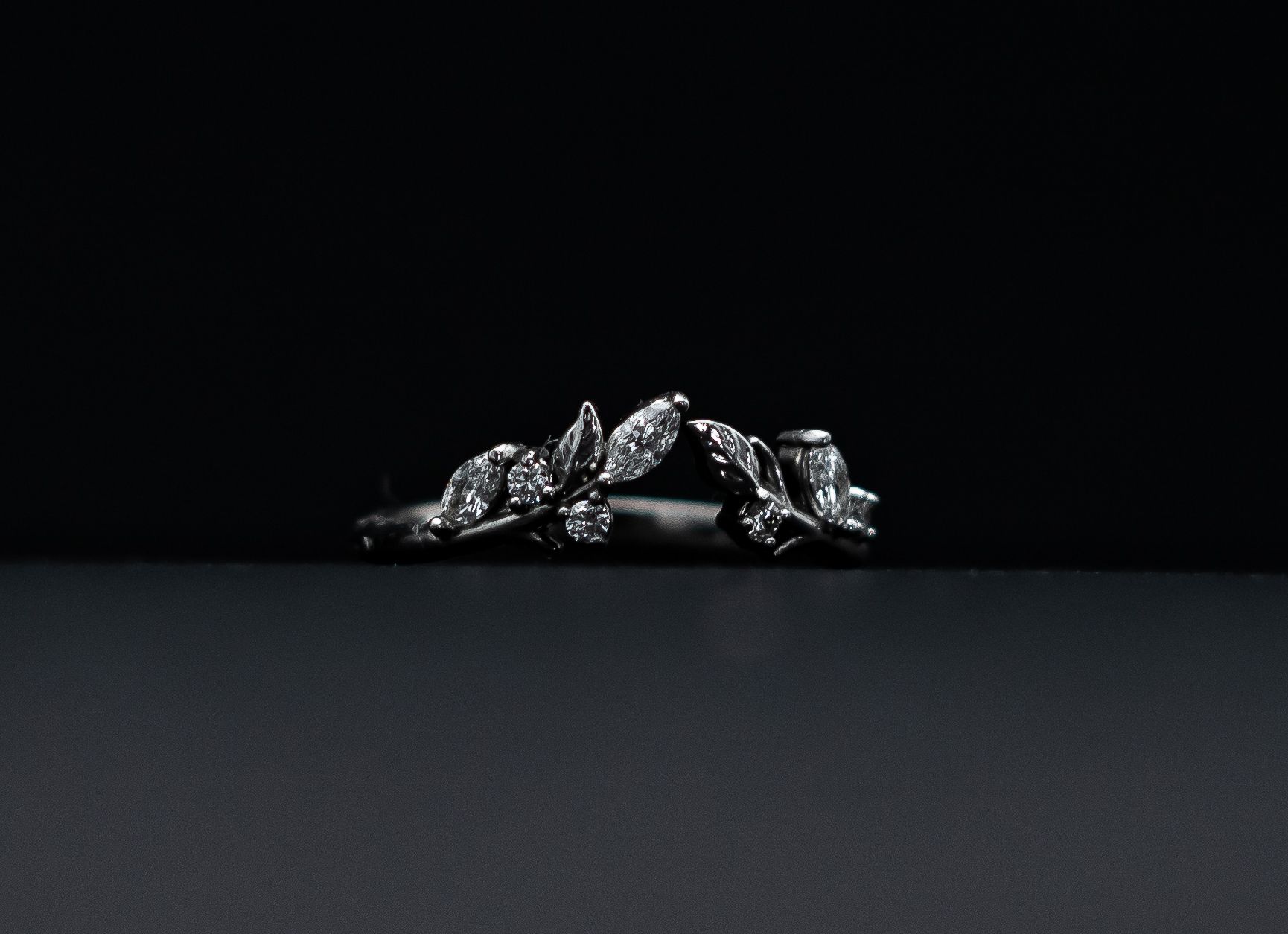 Black floral ring with sparkling stones on a dark background