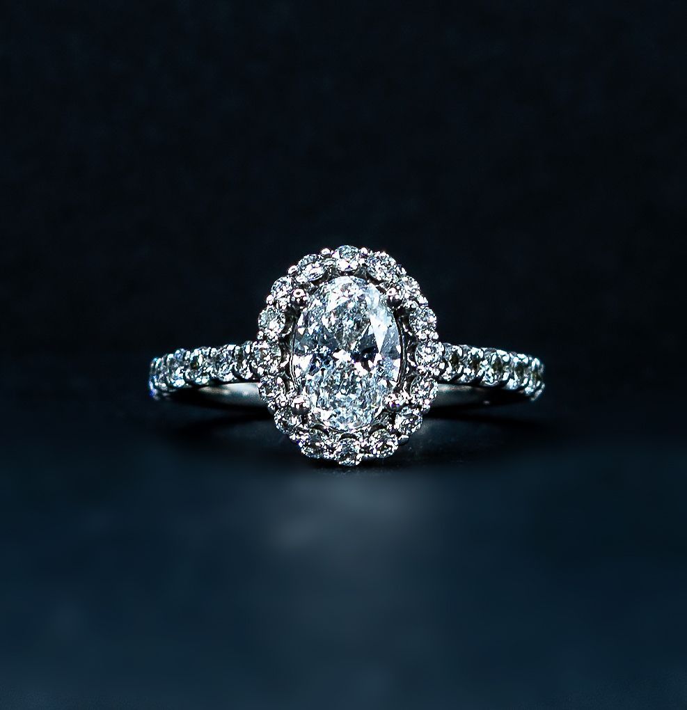Diamond halo engagement ring on a dark background