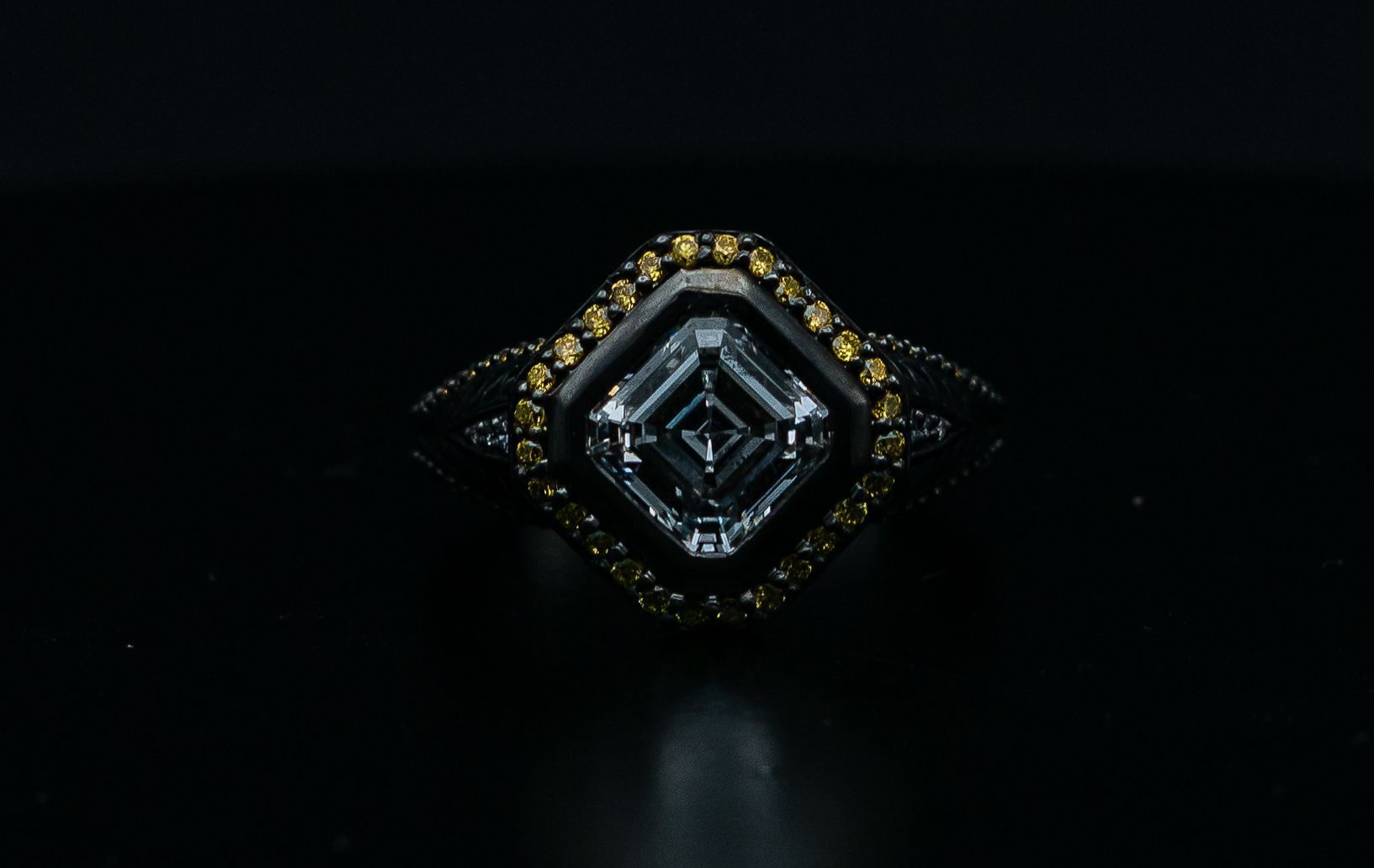 Diamond-shaped metallic object with gold accents on a dark background.