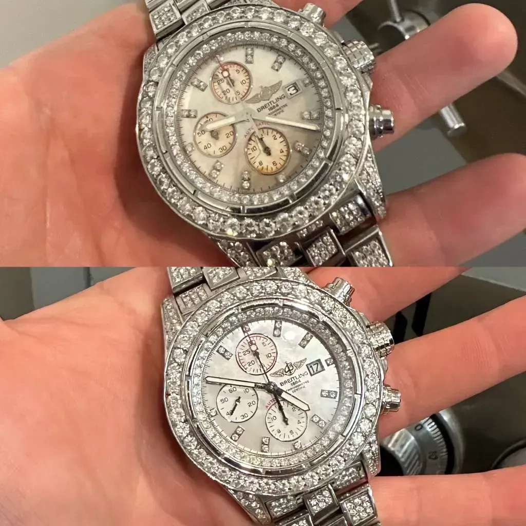 Two silver watches covered in diamonds, shown on a person's hand, one above the other.