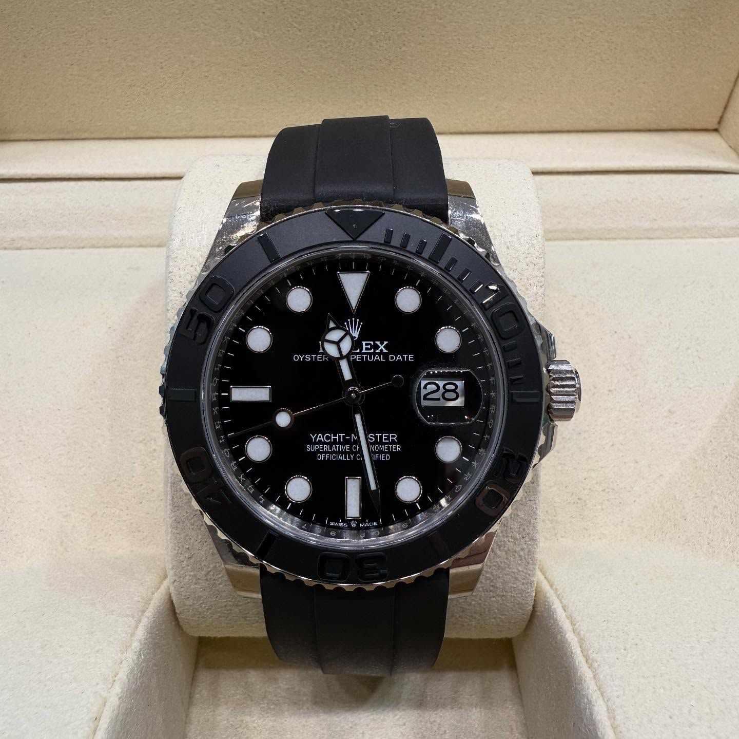 Black Rolex watch with rubber strap in a display case