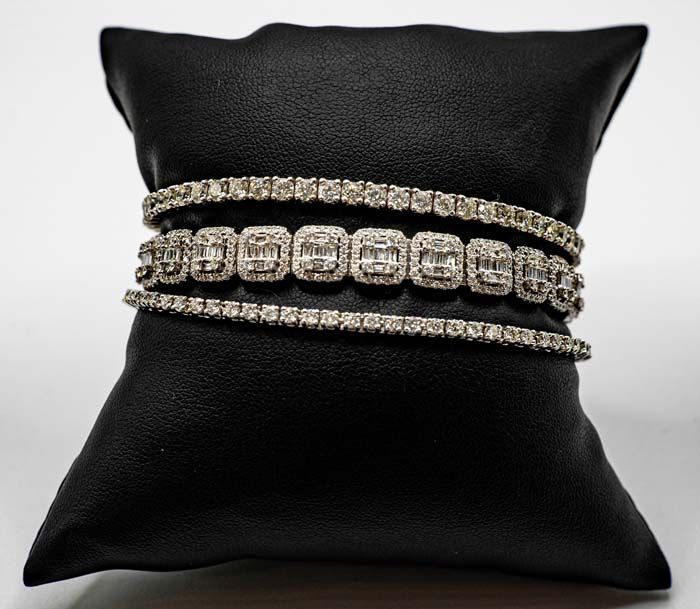 Black cushion displaying a gold and silver rhinestone bracelet set