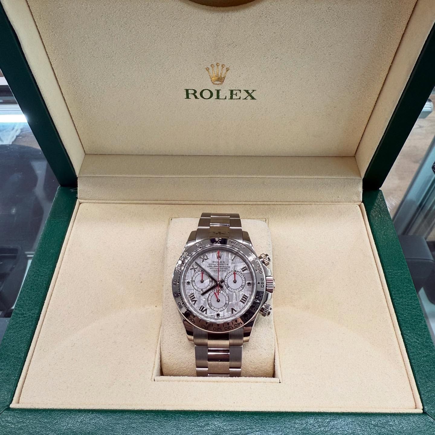 Rolex wristwatch in an open presentation box with cream lining and green exterior