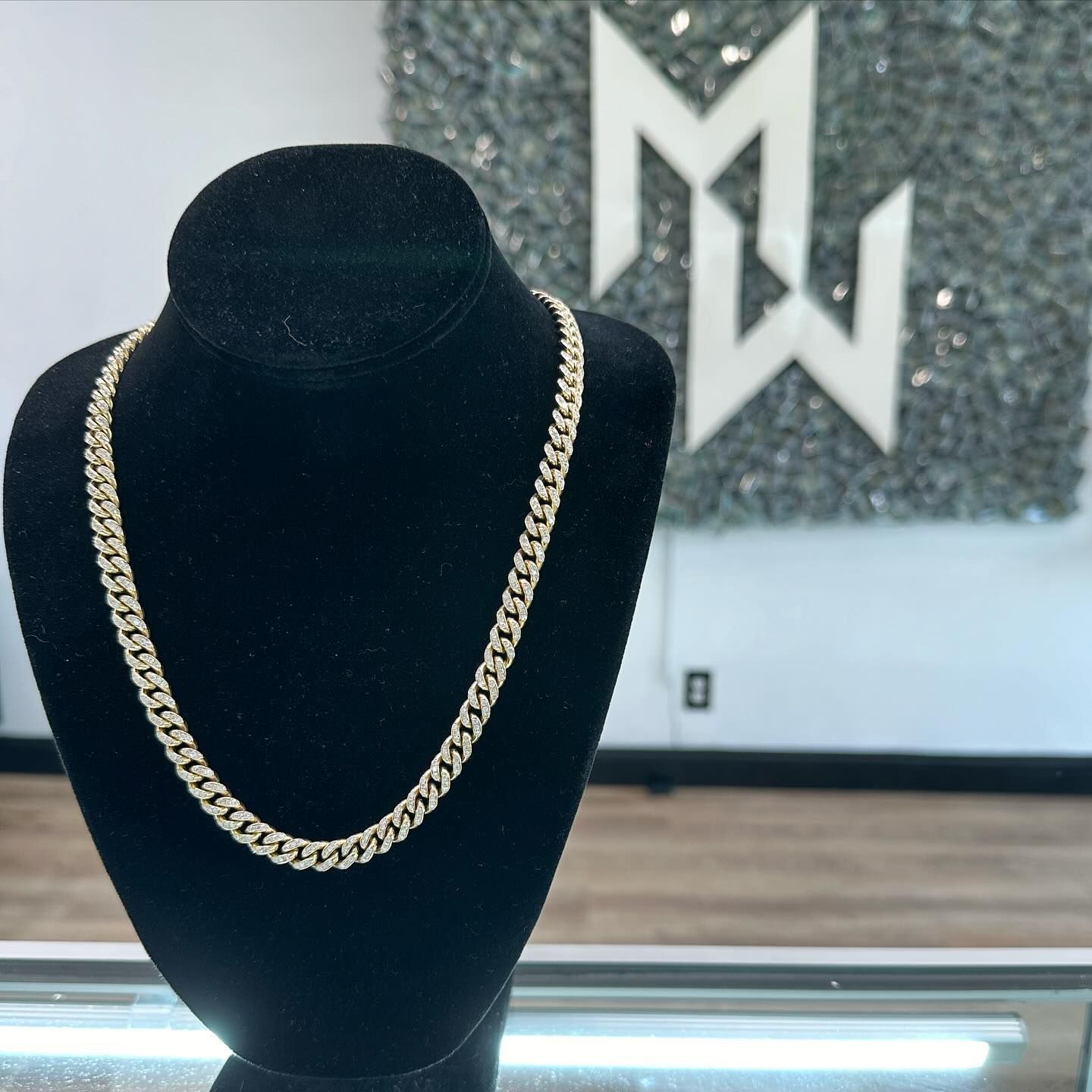 Gold chain necklace on a black velvet display bust in a jewelry store.