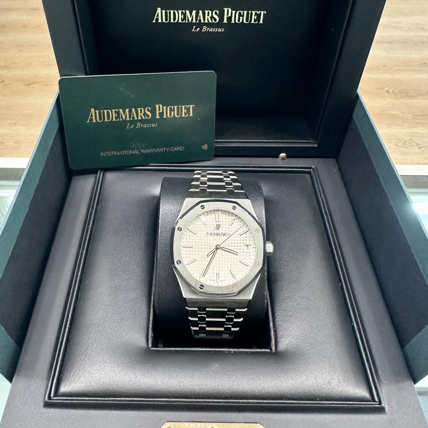 Audemars Piguet luxury watch in an open presentation box with branded case and card.
