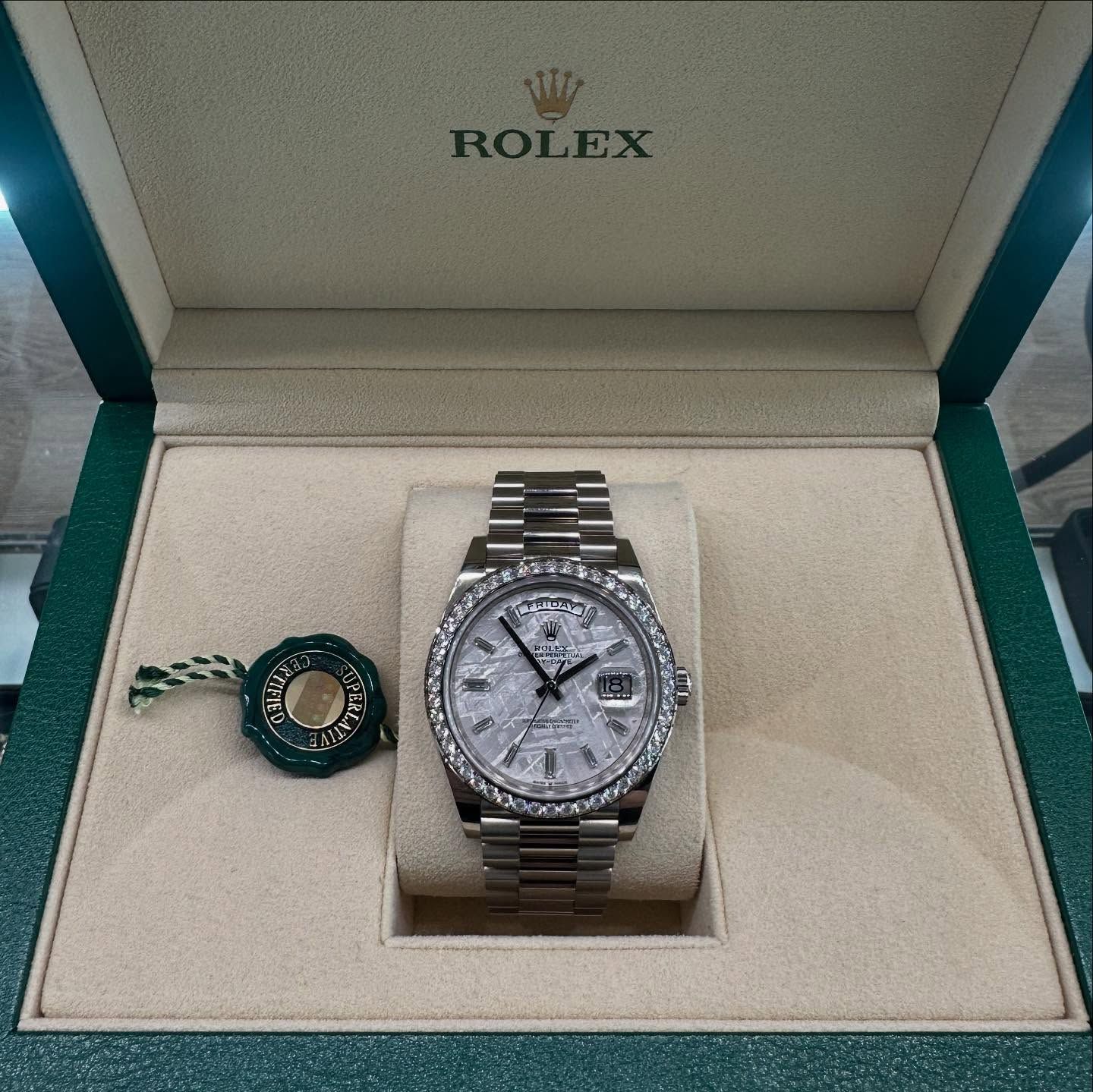Rolex watch in an open box with warranty card and tag