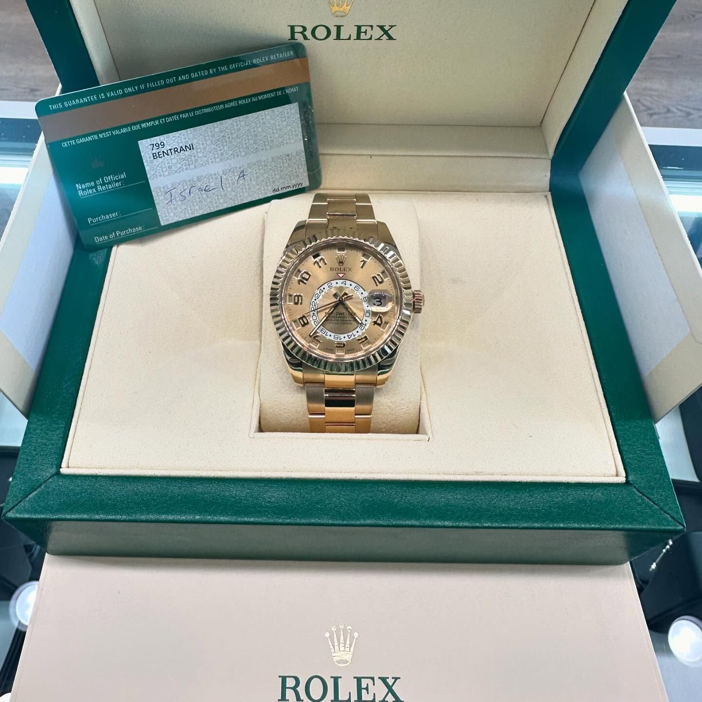 Gold Rolex watch in an open green Rolex box with paperwork inside