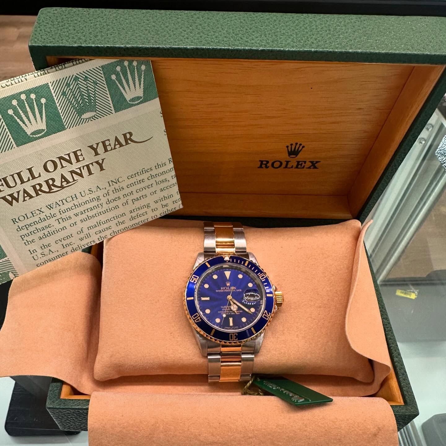Rolex watch in green presentation box with warranty card, blue dial and two-tone bracelet