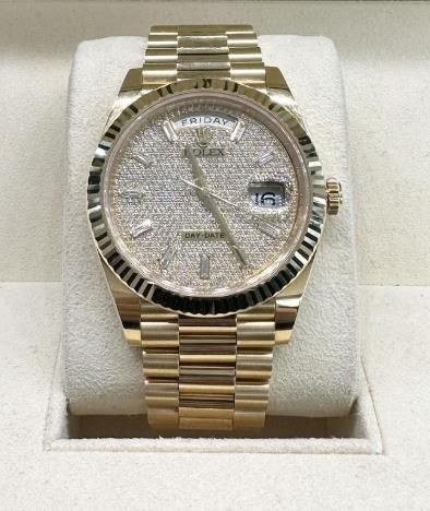 Gold wristwatch with diamond-studded face and fluted bezel in a display box