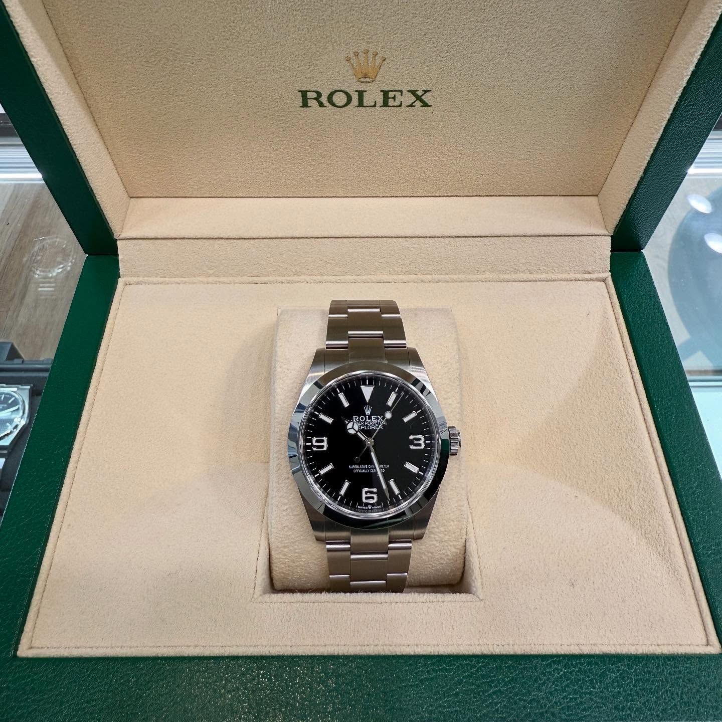 Rolex watch with black dial in a green presentation box