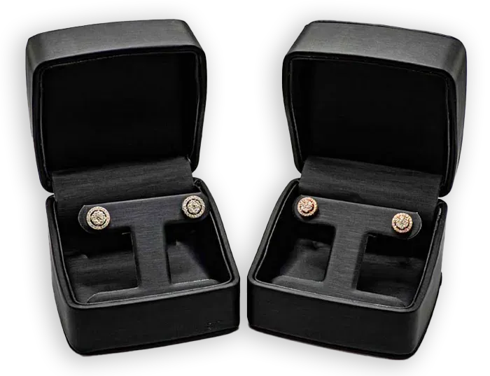 Two black velvet jewelry boxes with open lids, each holding a pair of cufflinks.