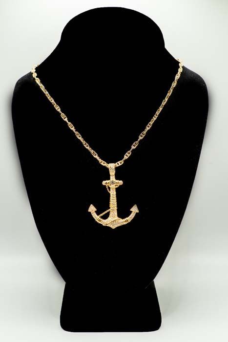 Gold anchor pendant necklace on a black display bust against a light background